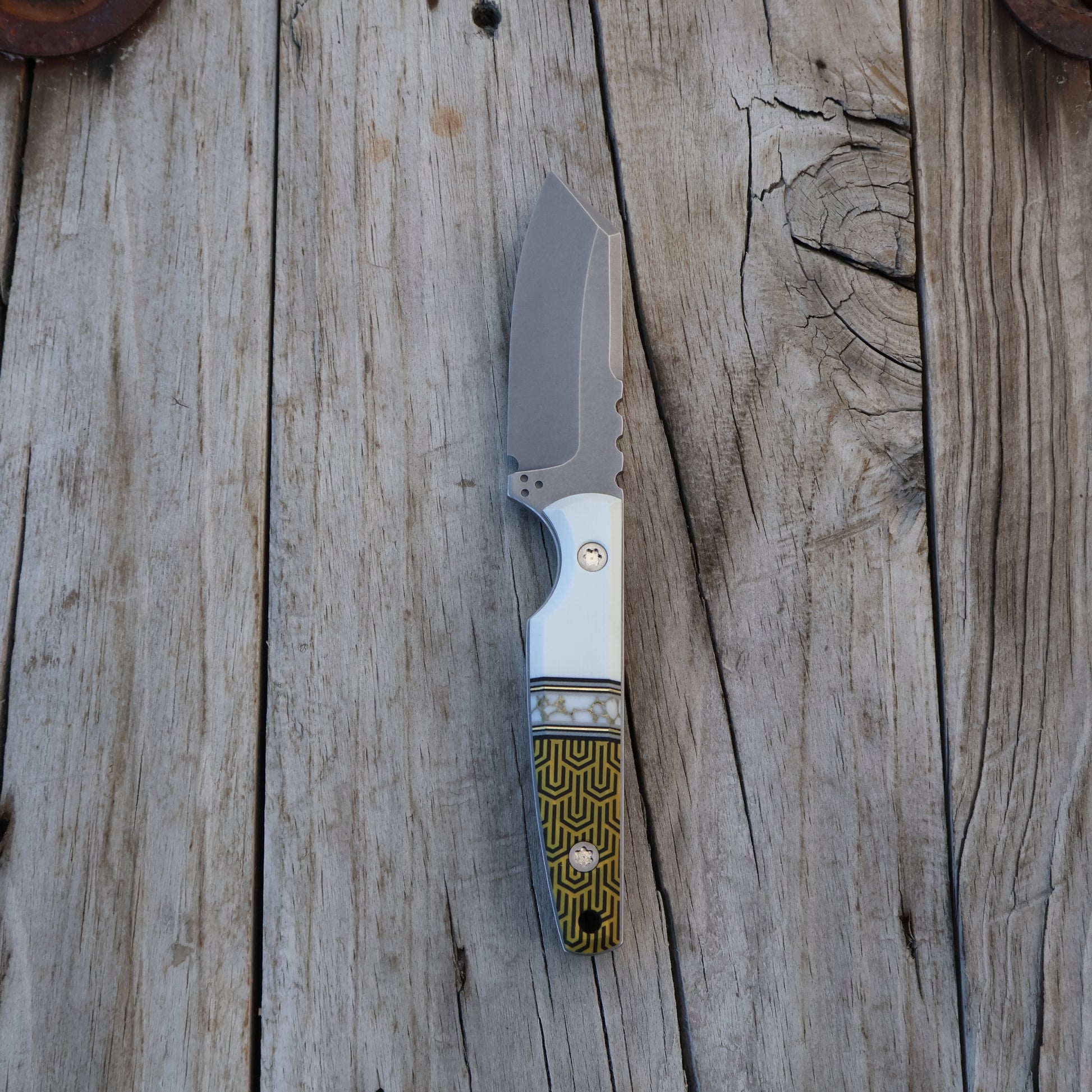 Fixed blade knife with a textured handle on a wooden surface