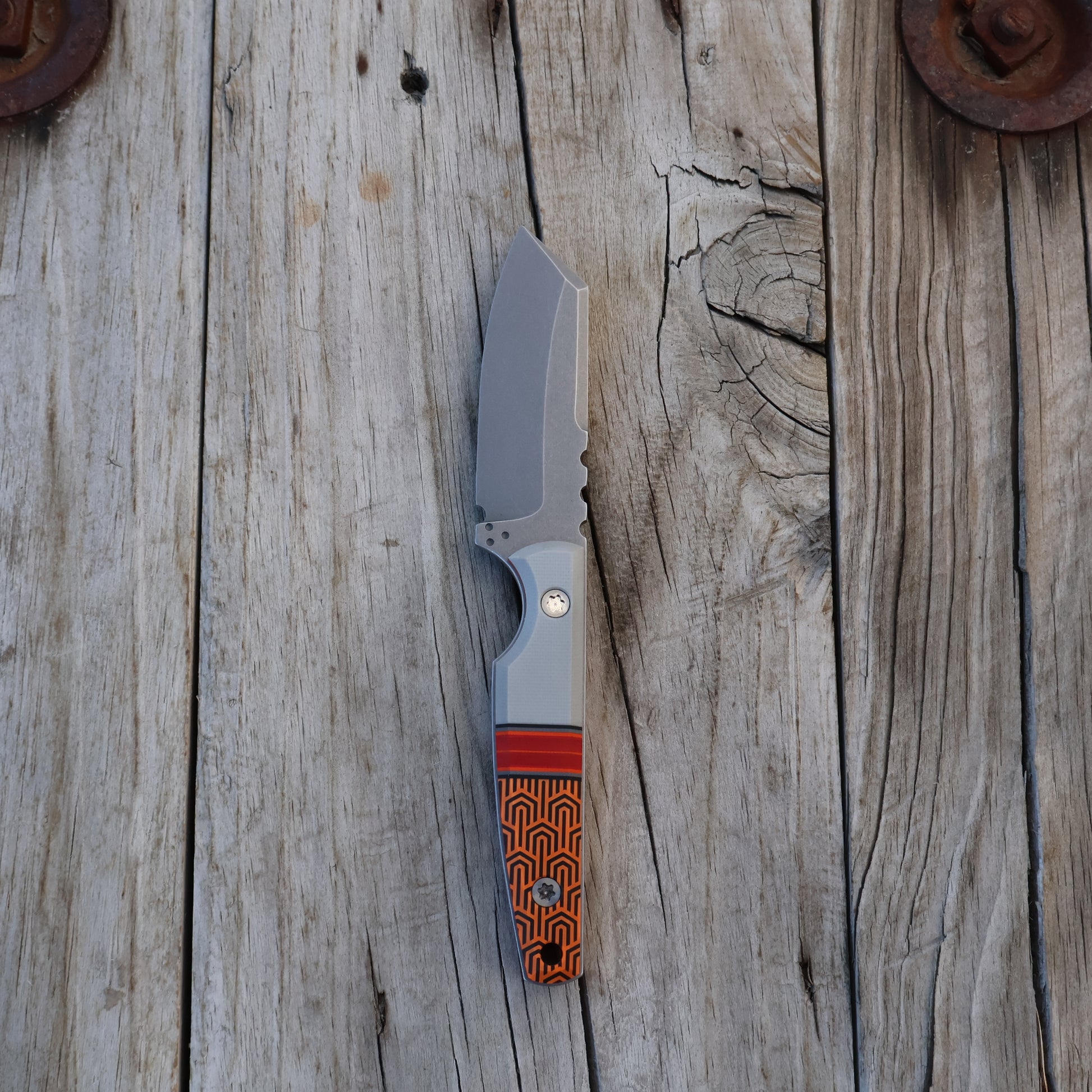 fixed blade knife with a geometric pattern on a wooden surface