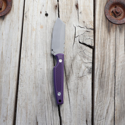Knife with textured purple handle on wooden surface 