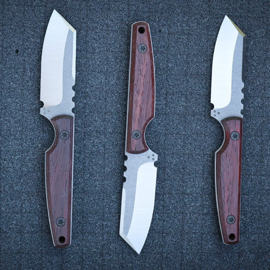 Three knives with wooden handles and metal blades on a black foam surface