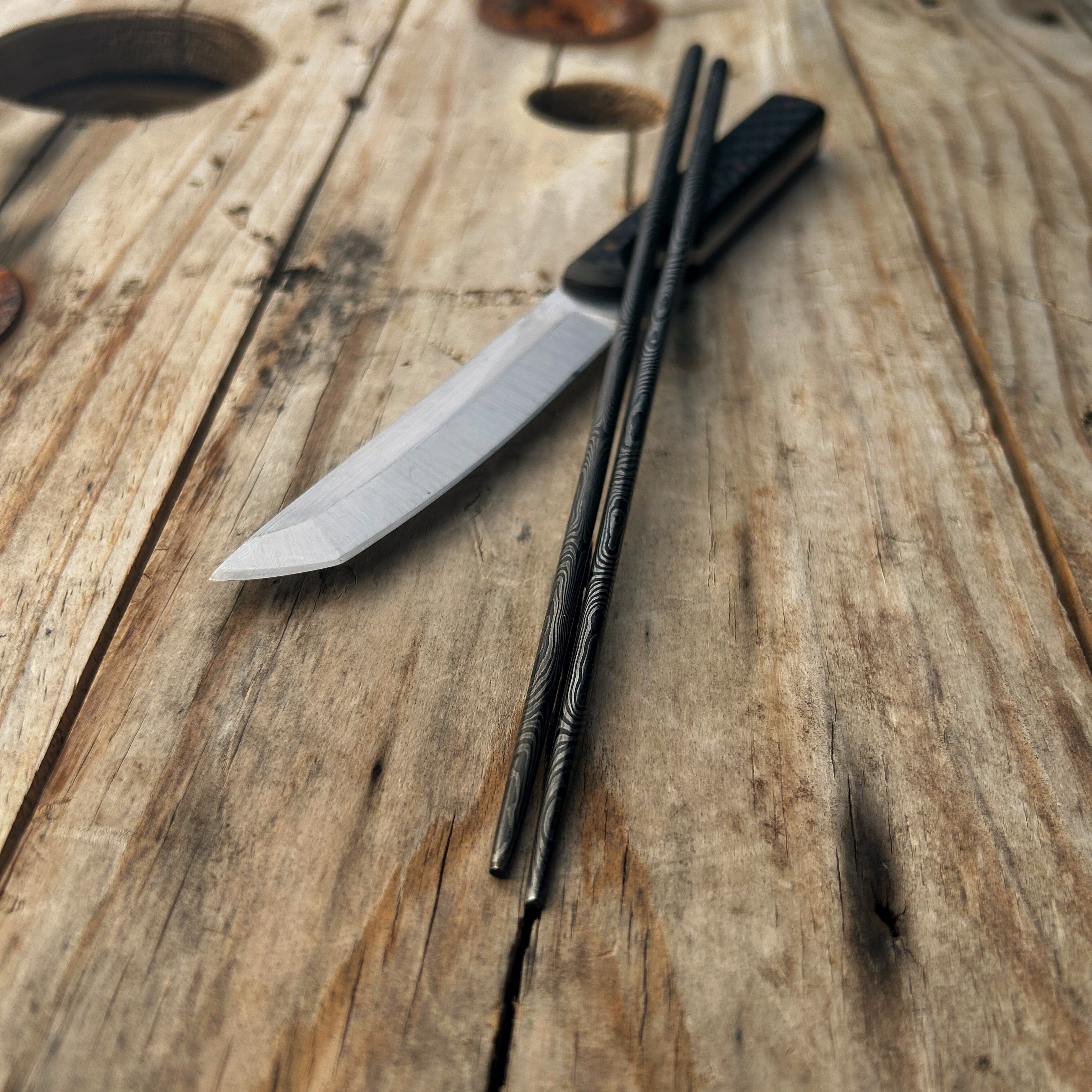 Damascus chopsticks propped up on tanto knife 