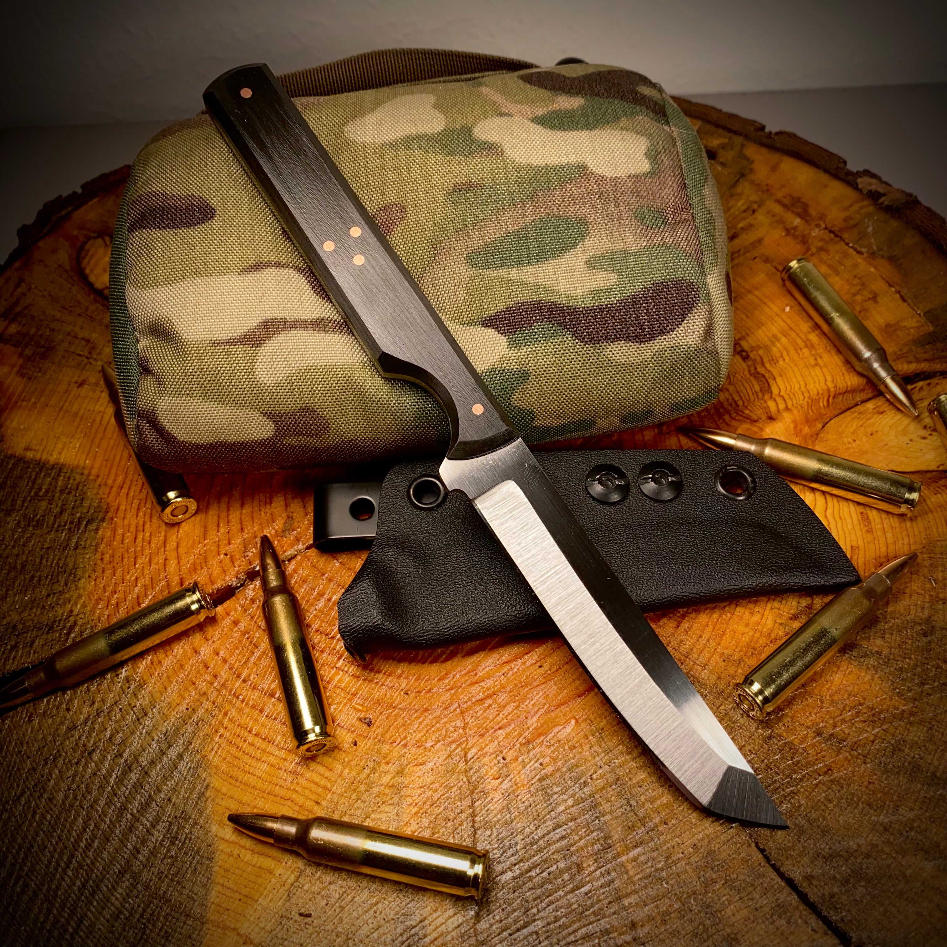 skinny tanto knife with camo back and brass surrounding it