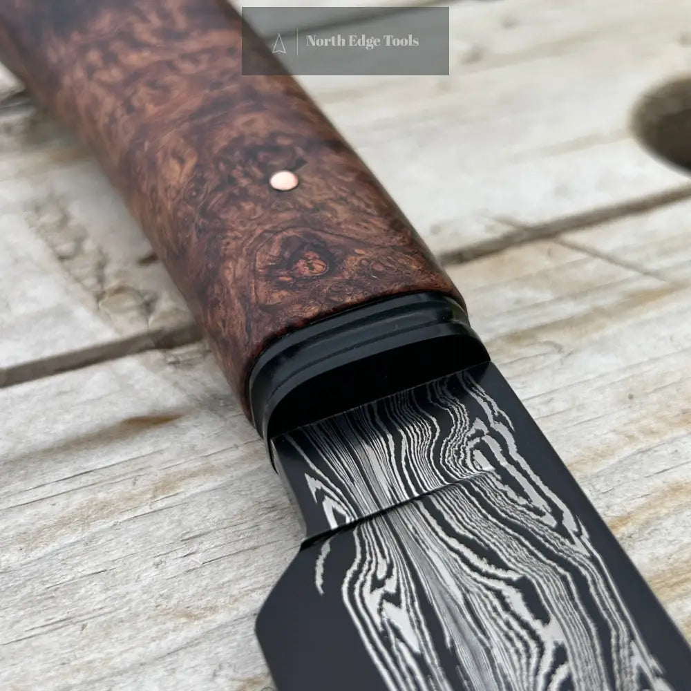 closeup of damscus blade and black fluted bolster